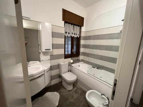 a bathroom with a sink and a toilet and a bath tub at Insieme è più bello in Sauze dʼOulx