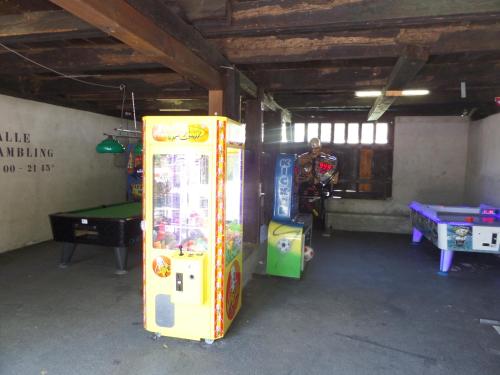 a room with a gaming machine and a table at Altogold Swiss Holidays At Manor Farm 5* in Interlaken