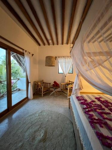 a bedroom with a bed and a room with a window at Boutique Villa Unaweza in Matemwe