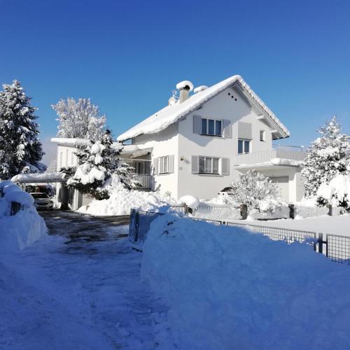 a white house with snow on the ground at Ferienhaus Hämmerle´s in Lustenau