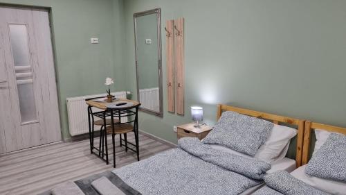 a bedroom with a bed and a table and a stool at Belvárosi Pihenőház in Békéscsaba