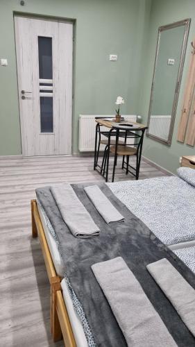 a room with two beds and a table and a tableasteryasteryasteryasteryastery at Belvárosi Pihenőház in Békéscsaba