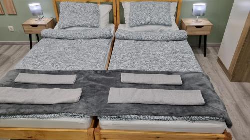 a pair of twin beds in a room at Belvárosi Pihenőház in Békéscsaba