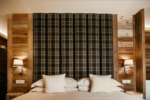 a bed with white pillows in a bedroom at Al Baitin - Charme & Nature - in Santa Caterina Valfurva