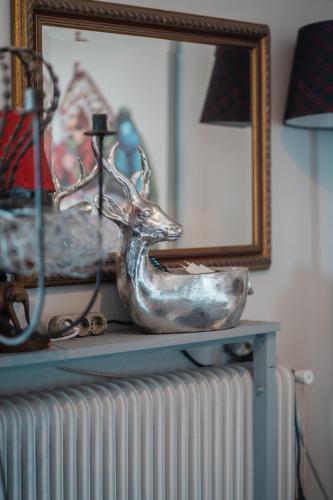 a statue of a deer on a radiator in front of a mirror at Ioanna's Hellenic Hospitality in Athens