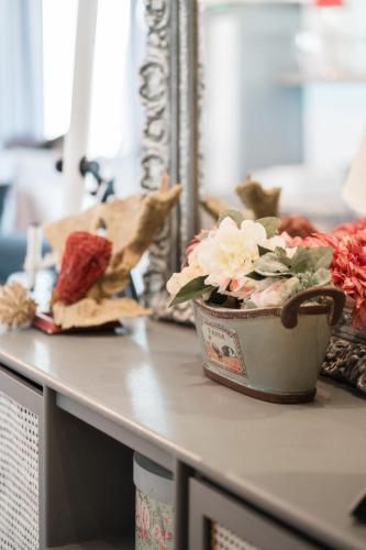 a table with a pot of flowers on it at Ioanna's Hellenic Hospitality in Athens