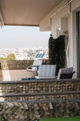 two chairs sitting on the balcony of a house at Ioanna's Hellenic Hospitality in Athens