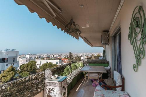 a balcony with a table and a view of a city at Ioanna's Hellenic Hospitality in Athens