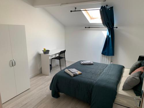 a bedroom with a bed and a desk and a window at Villa Tenjin Chambre 15 in Bondy