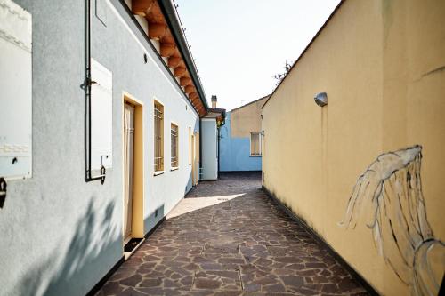 an alley between two buildings with graffiti on the walls at Loft del porto in Fano