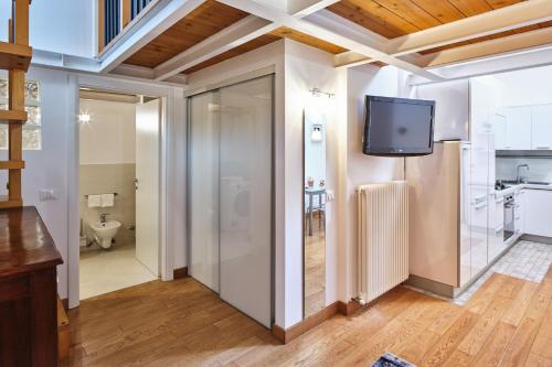 a bathroom with a sliding door and a tv on a wall at Loft del porto in Fano