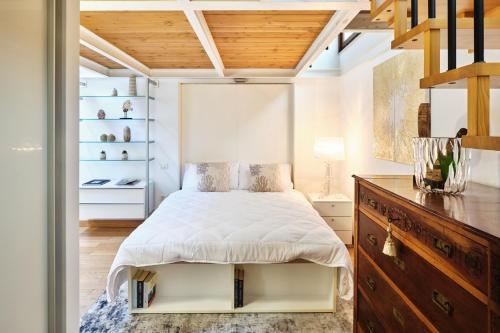 a bedroom with a white bed and a wooden ceiling at Loft del porto in Fano