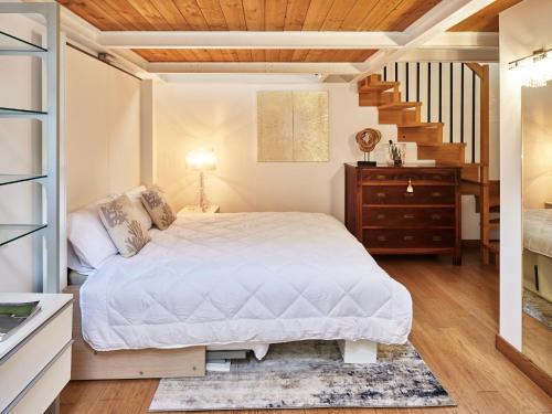 um quarto com uma cama branca e uma escada em Loft del porto em Fano