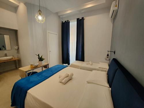 um quarto com 2 camas e uma janela com cortinas azuis em B&B Numero5 em Castellammare di Stabia
