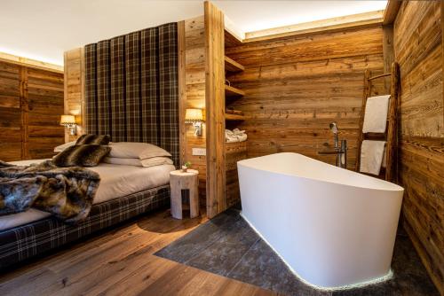 1 dormitorio con bañera y 1 cama en B&B Al Baitin - Charme & Nature - en Santa Caterina Valfurva