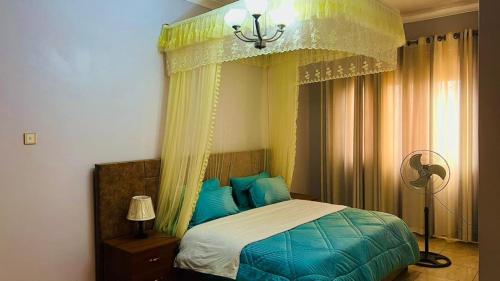 a bedroom with a bed with blue pillows at PALATINE APARTMENTS MAKINDYE KIZUNGU, KAMPALA in Kampala