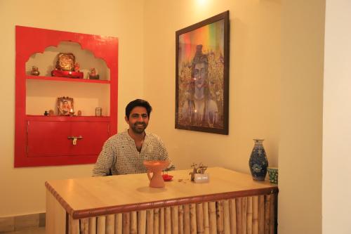 a man sitting at a table in a room at The Brahma Space in Pushkar