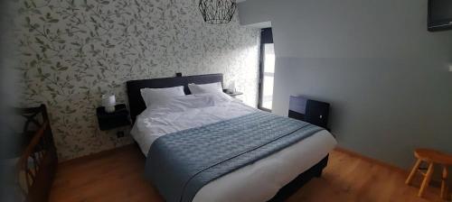 1 dormitorio con cama y pared en Watou's Uzeke, en Poperinge