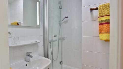 a white bathroom with a shower and a sink at Concordia - Wohnen auf Zeit in Frankfurt/Main