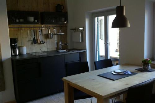 a kitchen with a wooden table with chairs and a dining room at Herberge. 46 in Garmisch-Partenkirchen