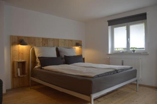 a bedroom with a large bed with a wooden headboard at Herberge. 46 in Garmisch-Partenkirchen