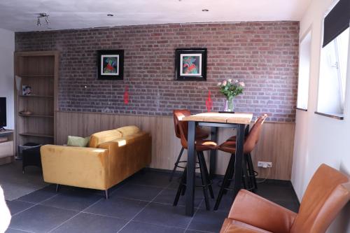 a room with a table and chairs and a brick wall at WijkD in Leende