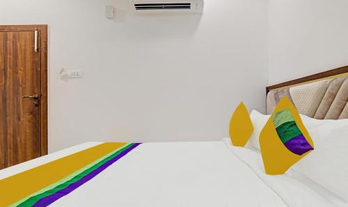 a bedroom with a bed with colorful pillows at Itsy Hotels Phoenix in Indore