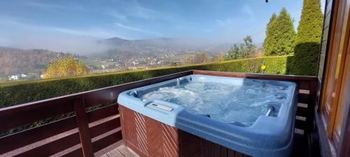 a hot tub on a balcony with a view at Urlopowa Chata in Targanice