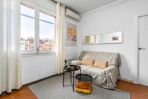 a living room with a couch and a table at Arc De Triomf - Solar & Spacious in Barcelona