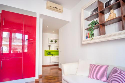 uma porta de correr vermelha numa sala de estar com um sofá branco em Appartamento nel cuore della città em Livorno