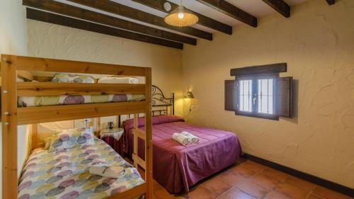 een slaapkamer met 2 stapelbedden en een raam bij Casa del Pino Casarabonela by Ruralidays in Casarabonela
