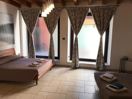 una camera con un letto e due grandi finestre di KINDLY ROBERTA centro storico Peschiera,lago relax a Peschiera del Garda