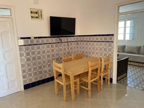 a dining room with a wooden table and chairs at Bienvenue chez vous in Tetouan