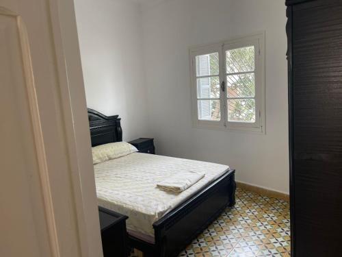 a small bedroom with a bed and a window at Bienvenue chez vous in Tetouan