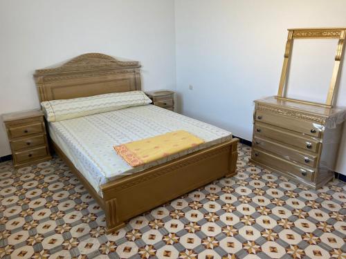 a bedroom with a bed and two dressers at Bienvenue chez vous in Tetouan
