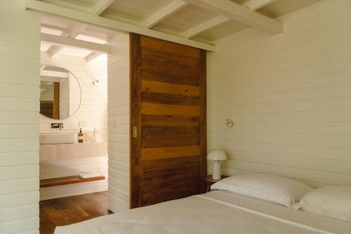 a bedroom with a bed and a wooden door at Kurulu Bay in Ahangama