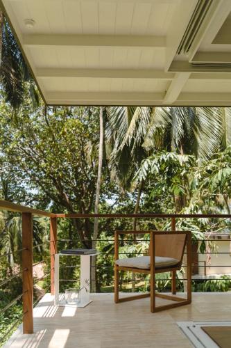 a chair on a porch with a view of trees at Kurulu Bay in Ahangama