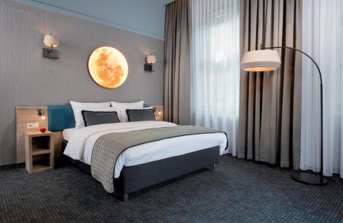 a bedroom with a large bed with a moon on the wall at Leonardo Boutique Hotel Krakow Old Town in Krakow