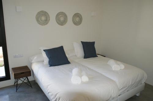 a bedroom with two beds with blue and white pillows at Extravagant Ibiza Villa Casa Tranquila SArgamassa 5 Bedrooms Fantastic Sea Views and Private Pool Santa Eulalia in Santa Eularia des Riu