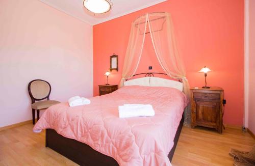 a bedroom with a pink bed with a mosquito net on it at Laconian Collection 'Magoula's Spacious Home' in Sparta