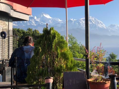 a person standing next to a christmas tree looking at a mountain at Hotel Pristine Himalaya in Pokhara