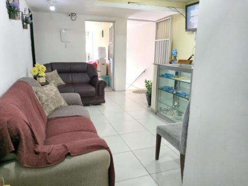 a living room with a couch and a chair at POUSADA LELÊ CONVENÇÕES in Recife