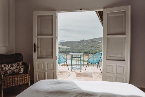 a bedroom with a door open to a patio with a table and chairs at Lake room 2 in Iznájar
