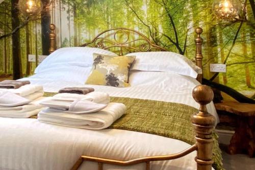 a bedroom with a bed with towels on it at Luxury tree-house with optional ESPA Spa in Canterbury