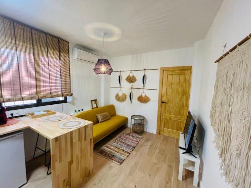 a living room with a yellow couch and a table at Casa del palmar junior in Valencia