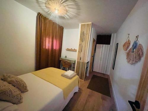 ein Schlafzimmer mit einem Bett, einem Tisch und einem Kronleuchter in der Unterkunft Casa del palmar junior in Valencia