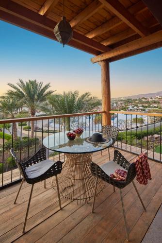 a patio with a table and chairs on a deck at Mövenpick Resort & Spa Tala Bay Aqaba in Aqaba