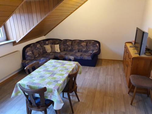 a living room with a couch and a table at Kleberhof - Urlaub auf dem Bauernhof in Eslarn