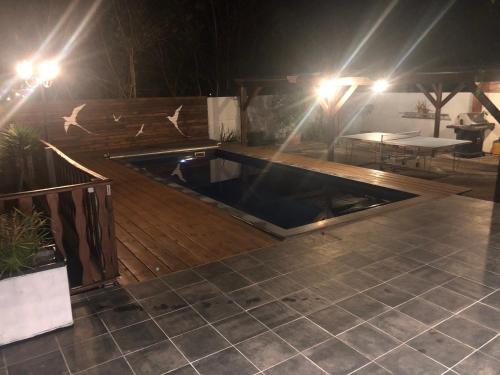 a hot tub on a deck at night with lights at La Kaz Paille en Queue, Magnifique Villa F5 récemment rénovée avec piscine et Jacuzzi sur La Possession in La Possession