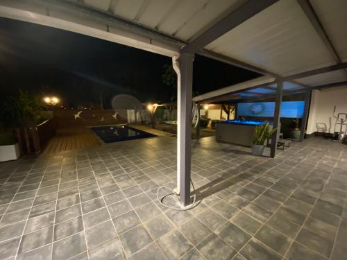 an outdoor patio at night with a pavilion at La Kaz Paille en Queue, Magnifique Villa F5 récemment rénovée avec piscine et Jacuzzi sur La Possession in La Possession